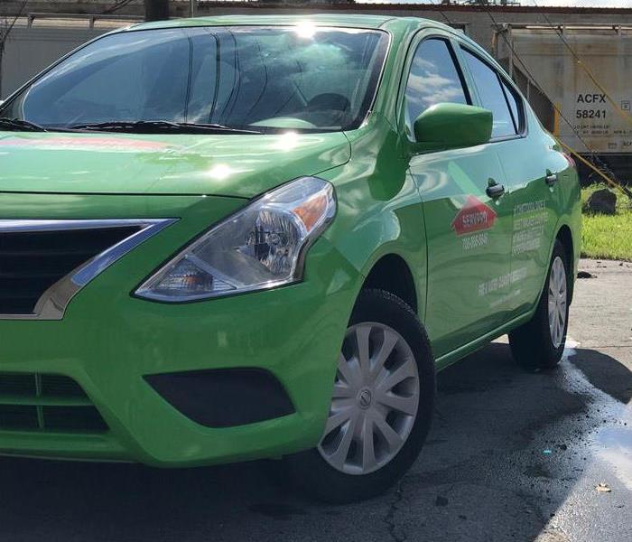 Green SERVPRO car outside of a commercial building