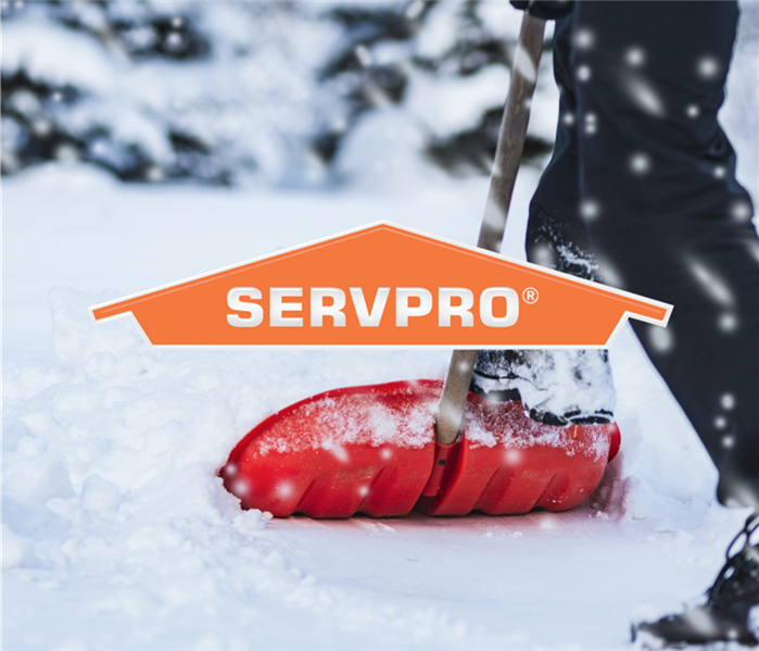 someone shoveling thick snow with the SERVPRO logo on top of the photo 