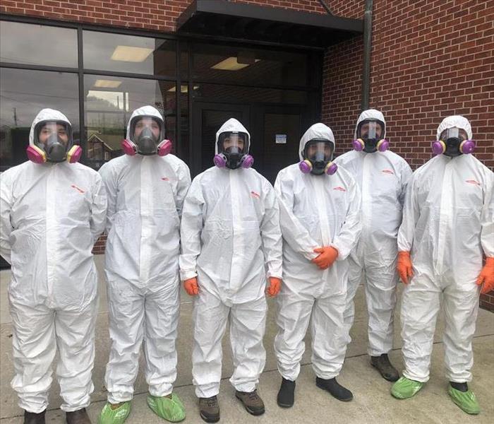 SERVPRO employees in hazmat suits cleaning 
